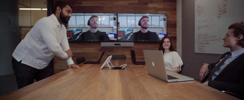 People meeting in a hybrid conference room.